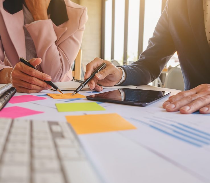 Business concept. Business people discussing the charts and graphs showing the results of their successful teamwork. Selective focus.
